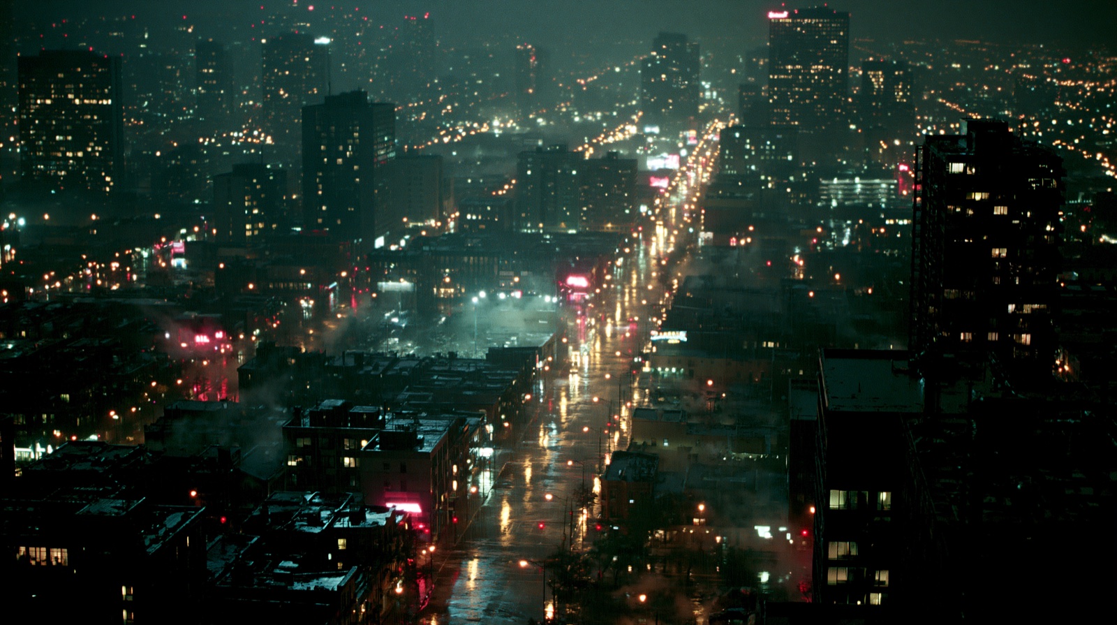 Rain-soaked city aerial at night