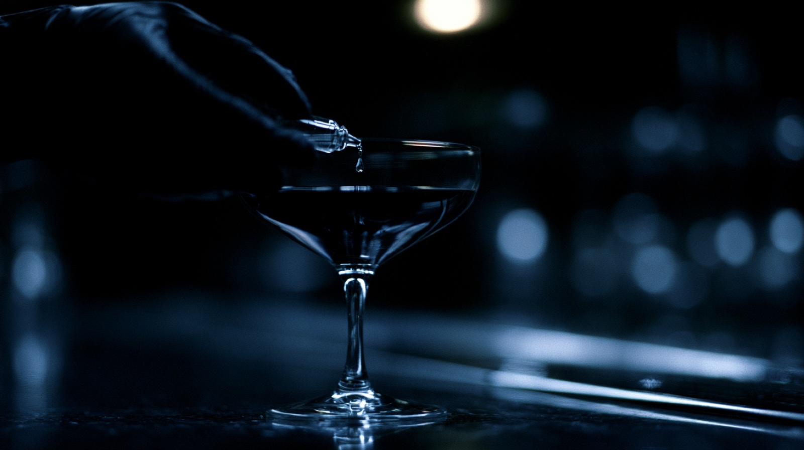 Liquid poured into a coupe glass in low light
